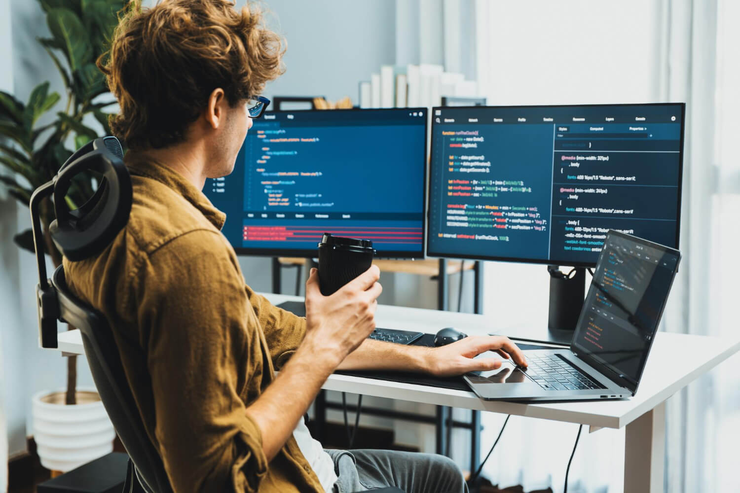 Software developer working with multiple screens